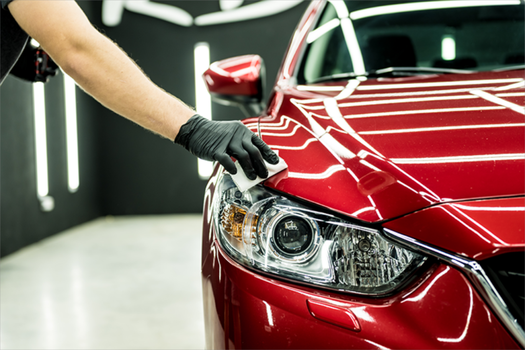"Technician performing professional detailing on a car, showcasing PRO LINE’s premium shine and finish"
